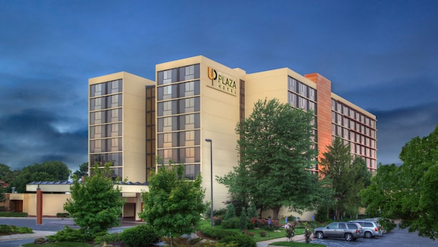 A modern hotel with a prominent sign, multiple floors, and a parking area.