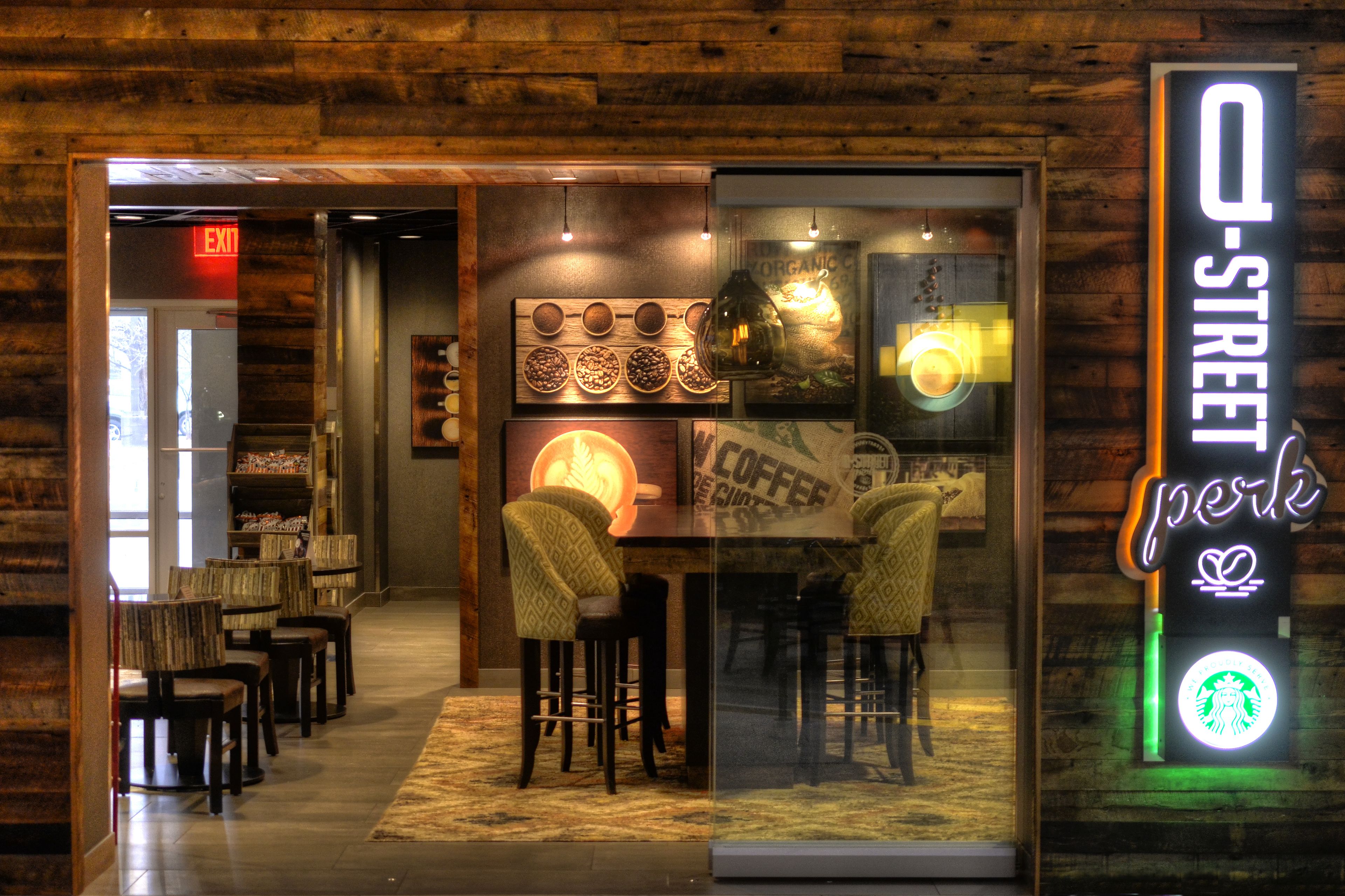 A coffee shop interior with wooden walls, a neon sign, and a display of coffee beans.