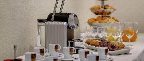 Un bufé de desayuno con café, té, muffins y fruta.
