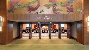 A large ballroom with a sign reading "Prince Ballroom" and rows of tables and chairs.