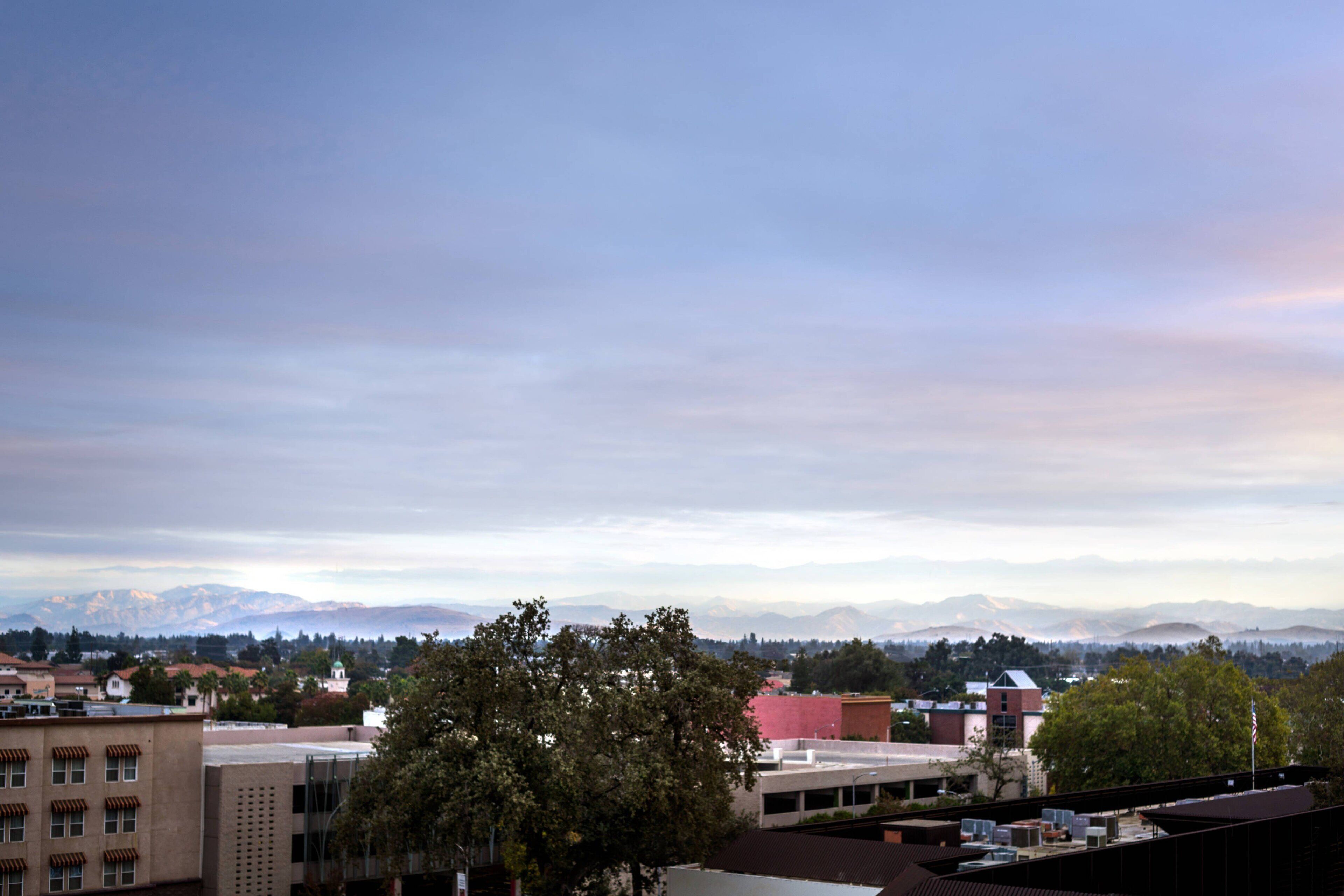 A cityscape with buildings and mountains in the background.
