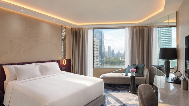 Hotelkamer met een groot bed, een bureau met stoel, uitzicht op de stad en een modern plafondontwerp.