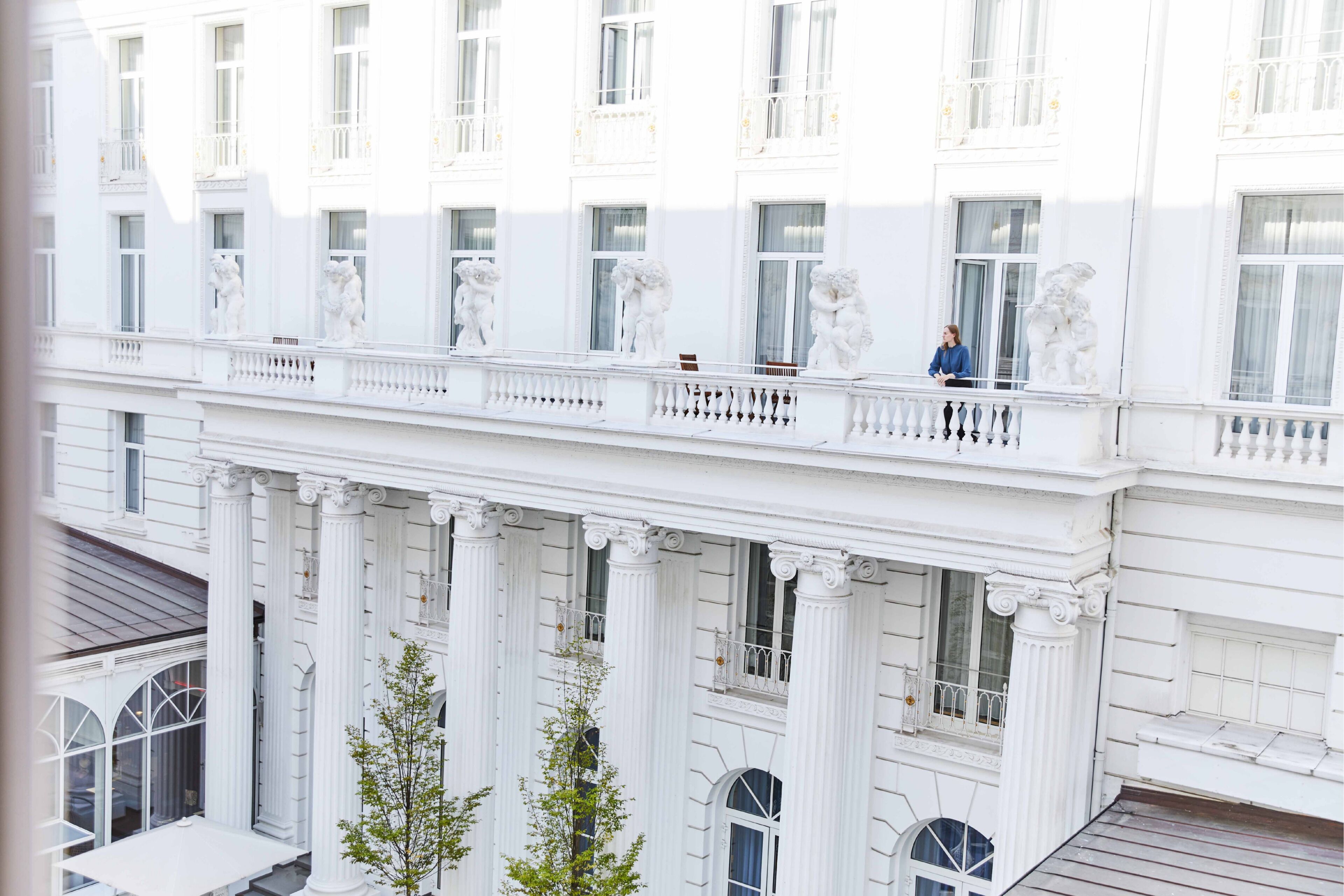 Un edificio de varios pisos con arquitectura clásica, que presenta columnas, balcones y ventanas amplias.