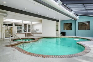 An indoor swimming pool with a clear view of the surrounding area, including a staircase and seating area. - Best Western Seattle Airport Hotel (SeaTac)