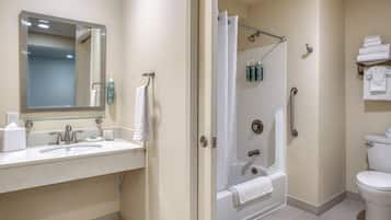 Un baño con lavamanos, espejo, ducha e inodoro.