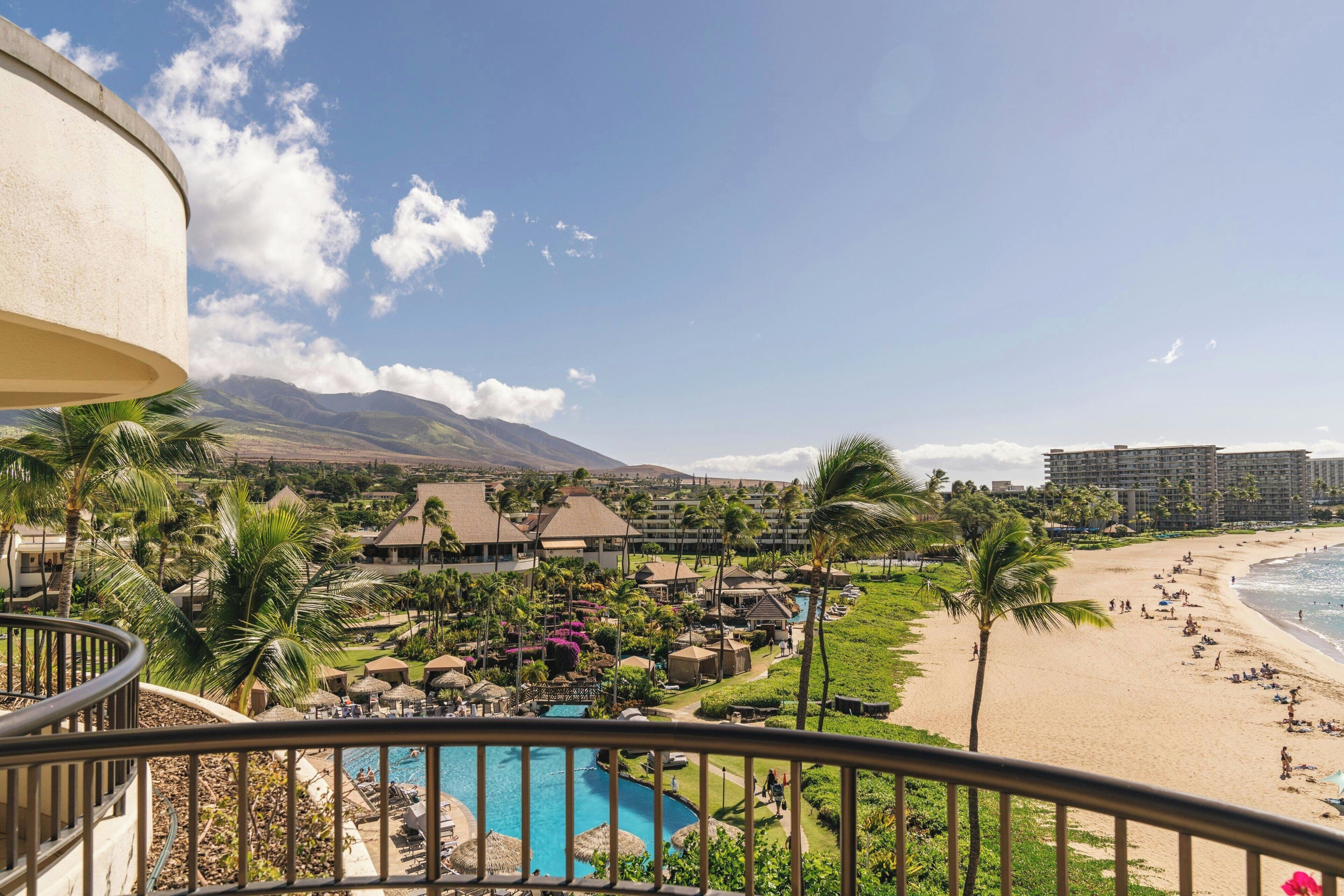 A resort with a pool, beach, and mountain views.