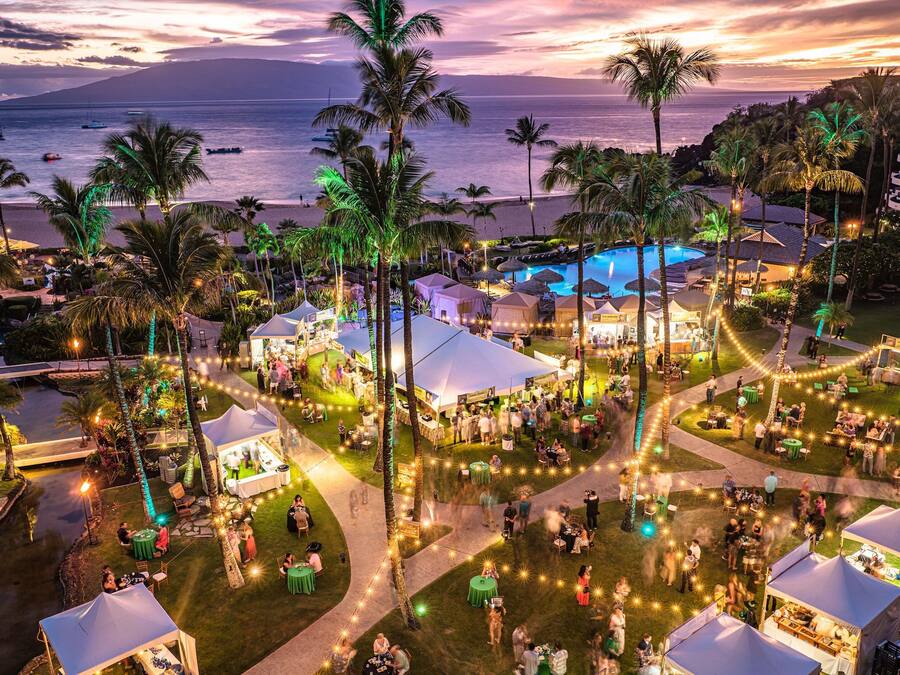Un resort con piscina, tiendas de campaña, palmeras y vistas al océano.
