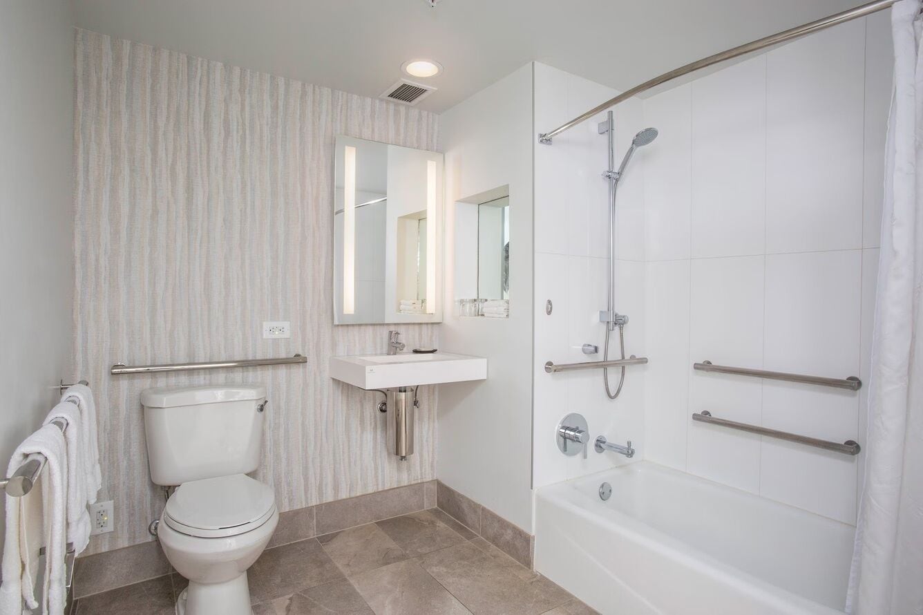 Une salle de bain moderne équipée de toilettes, d’un lavabo et d’une douche.