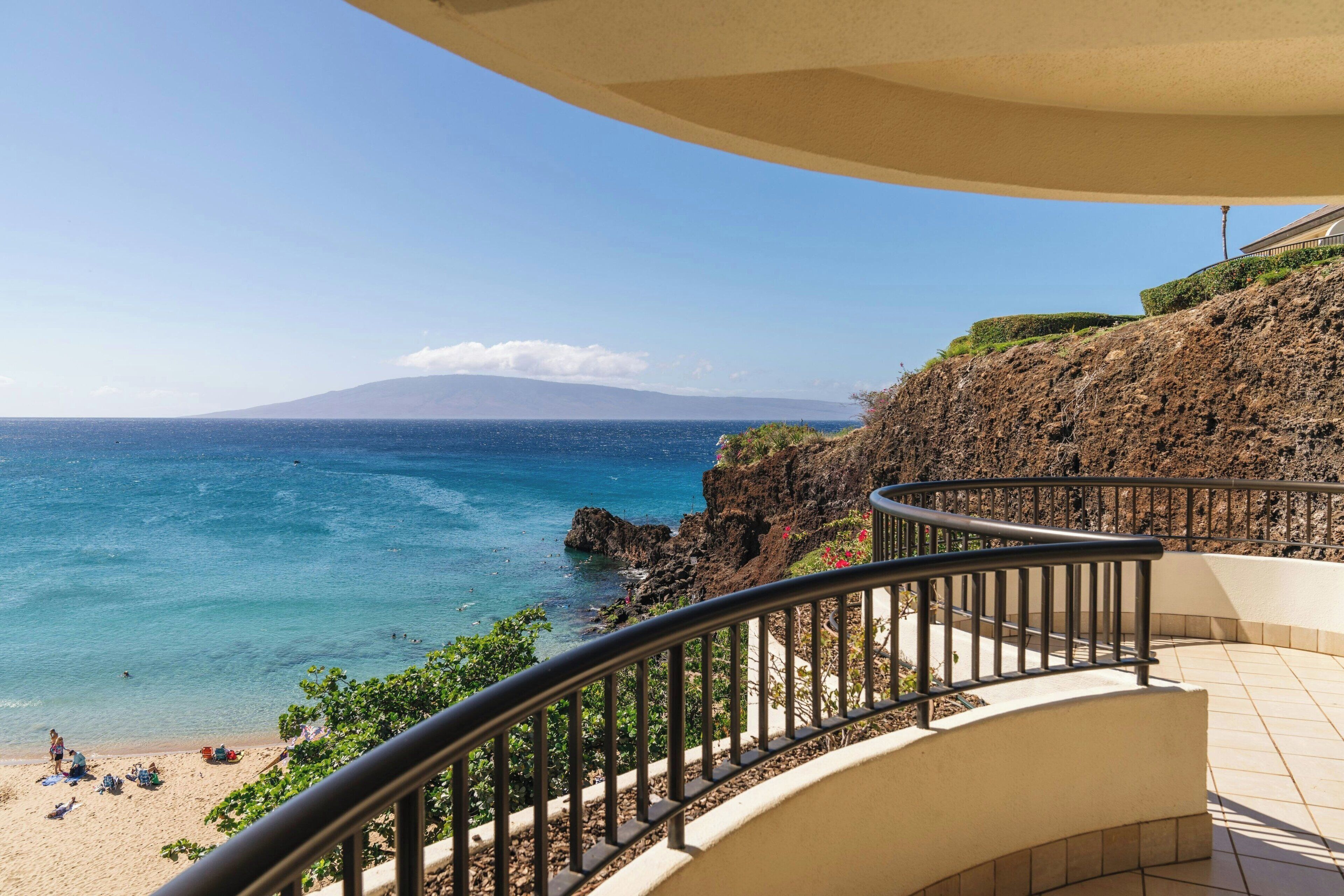 A balcony with a view of a beach and ocean.
