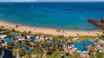 Una piscina al aire libre, camas de piscina con cargo, sombrillas