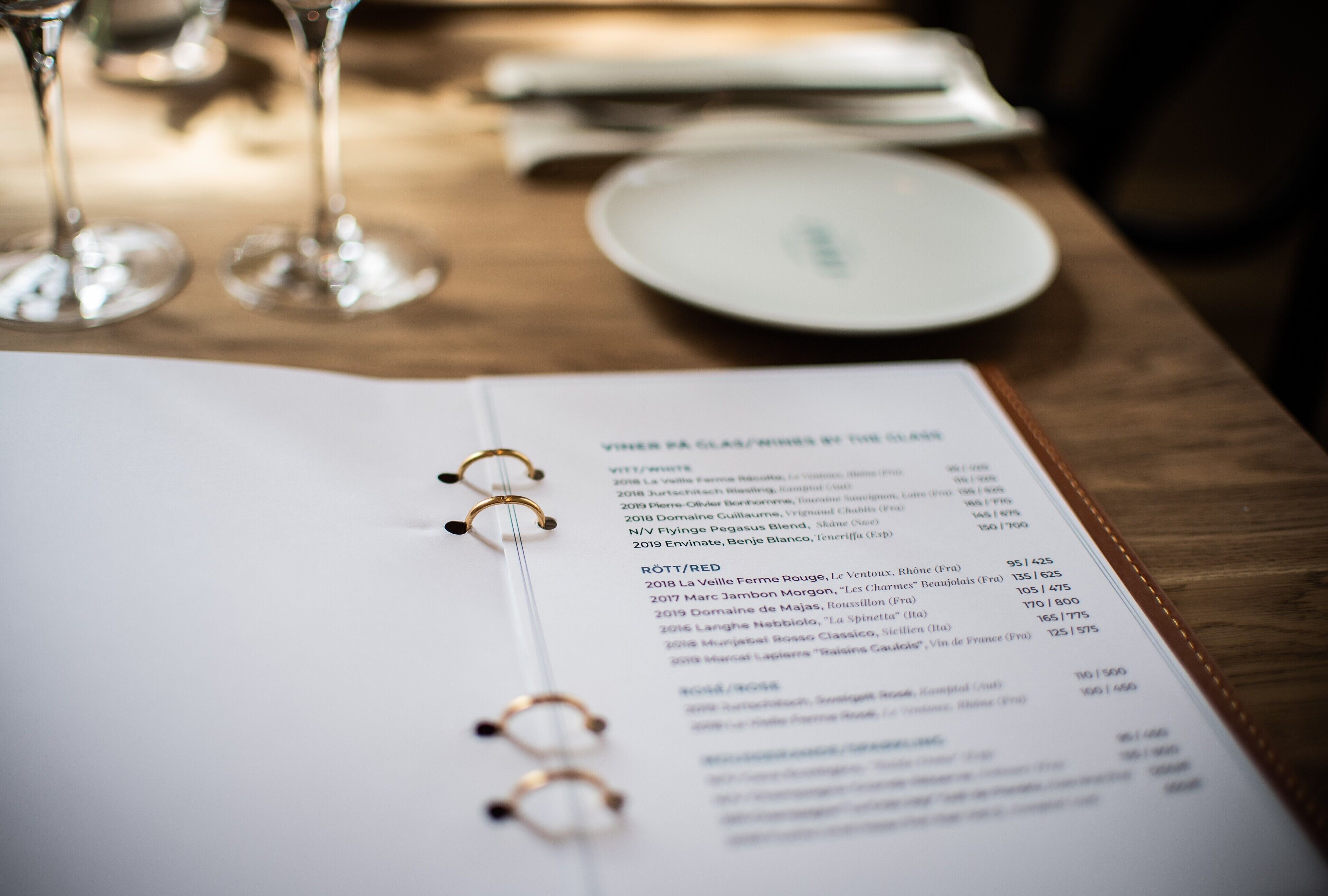 A menu with wine and cheese pairings on a wooden table.
