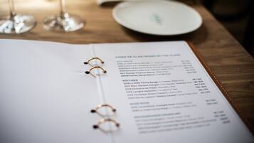 A menu with wine and cheese pairings on a wooden table.