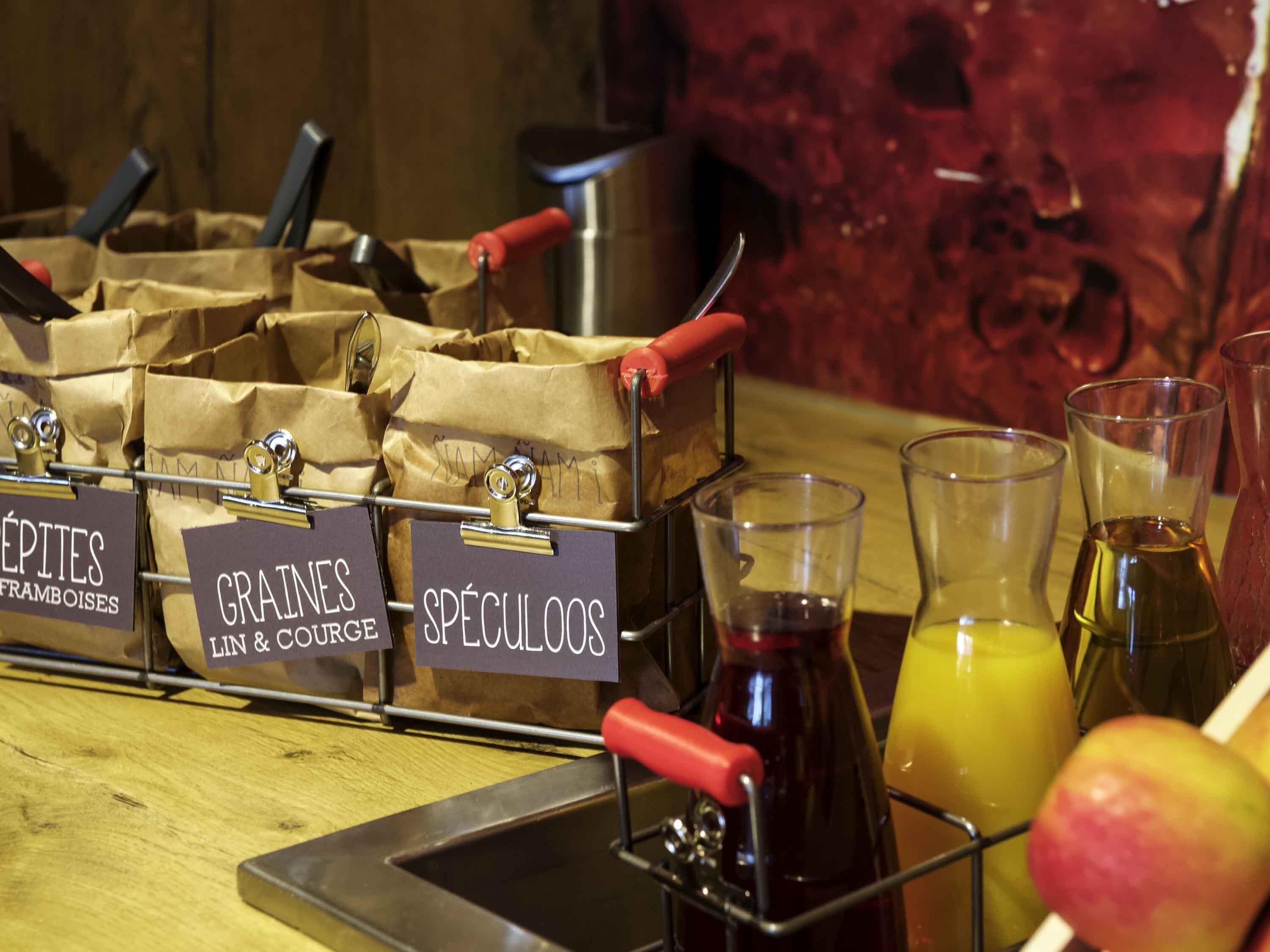 Een bar met drankdispensers, gelabeld voor 'FRAMBOISES', 'GRAINES LIN & COUPE' en 'SPÉCULOOS'.