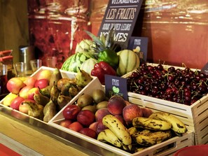A fruit display with various types of fruits including apples, pears, peaches, cherries, and bananas.
