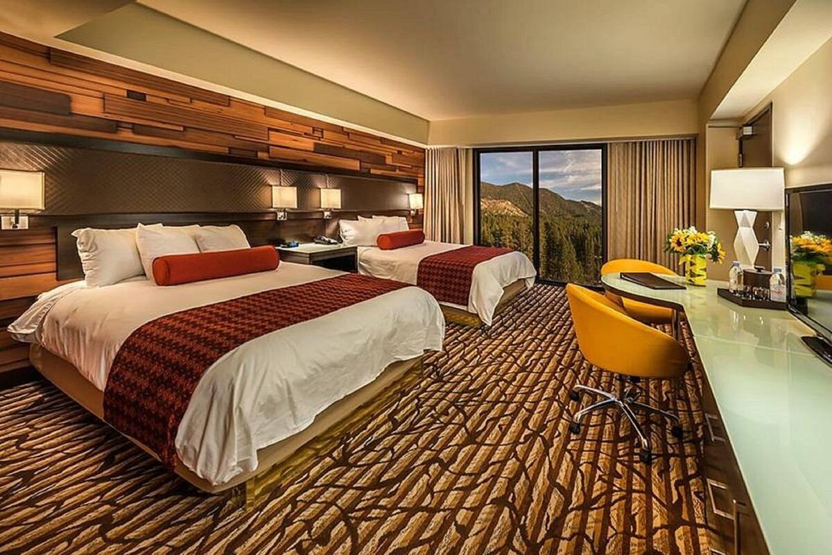 Ein Hotelzimmer mit zwei Betten, einem Schreibtisch und einem Stuhl.