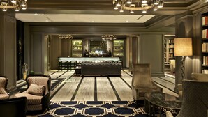 Un lobby de hotel lujoso con bar, zona de estar y un amplio sofá.
