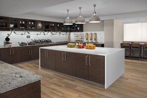 A modern kitchen with dark wooden cabinets, a central island, and pendant lighting. - Residence Inn Washington, DC/Foggy Bottom (Washington)