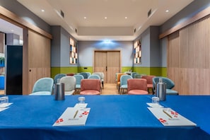 A conference room with a long table, multiple chairs, and a wooden door at the end. - Hilton Garden Inn Rome Colosseum (Rome)