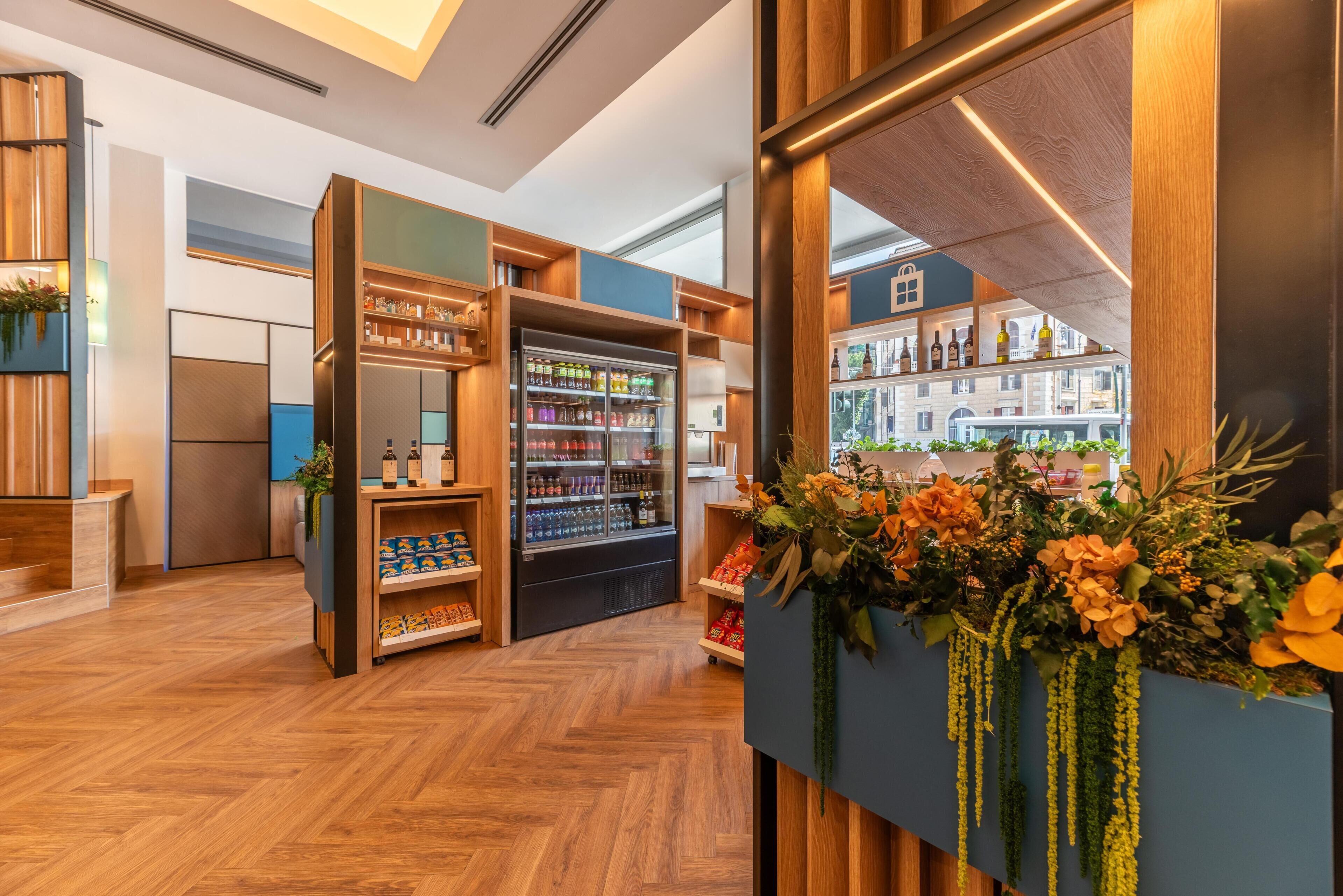 A modern retail space with wooden shelving, refrigerated display cases, and a view of the city through large windows.