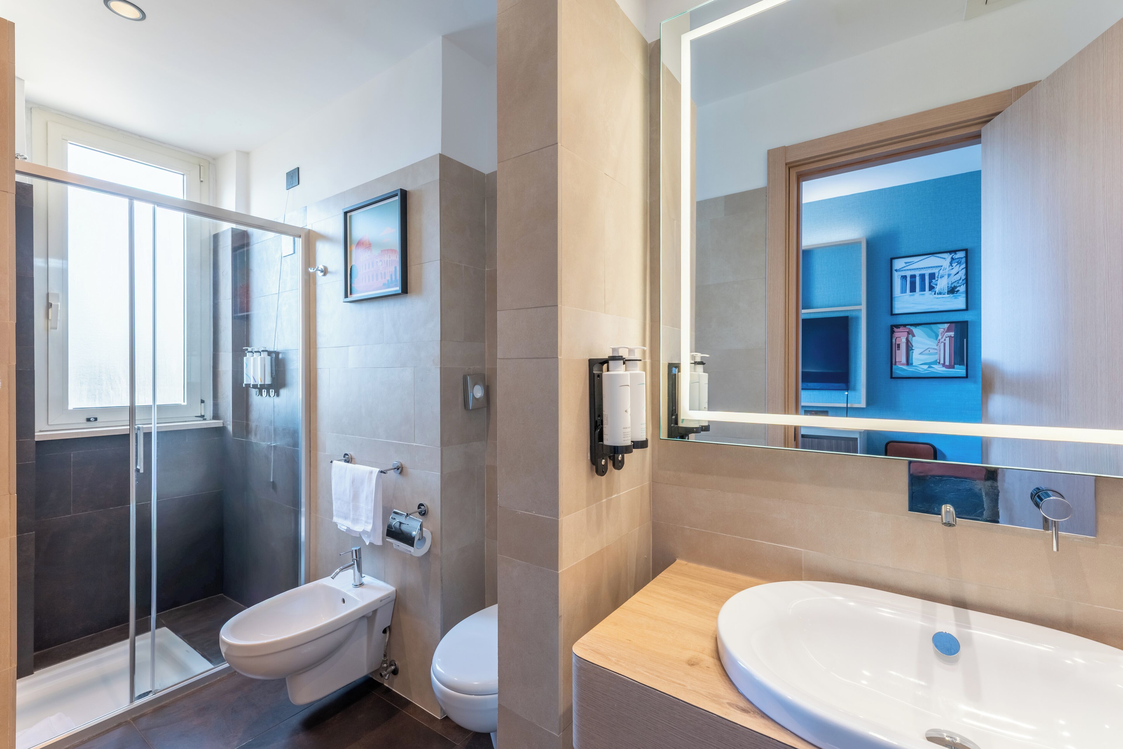 A modern bathroom with a glass shower enclosure, a toilet, and a sink with a mirror above.