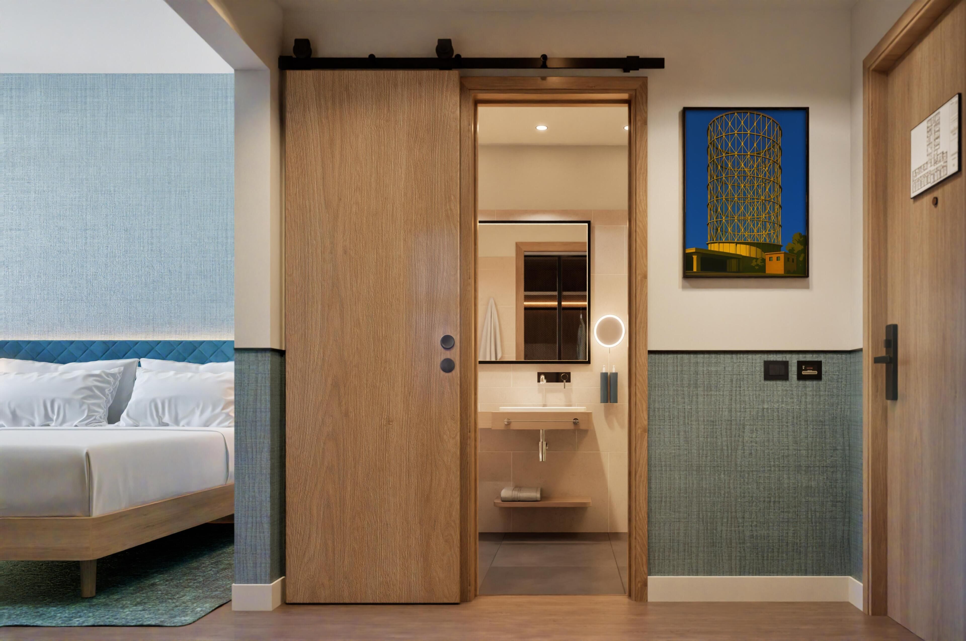 A hotel room with a bed, a bathroom with a sink and mirror, and a door leading to another room.
