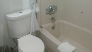 Un baño con inodoro, bañera y cortina de ducha.