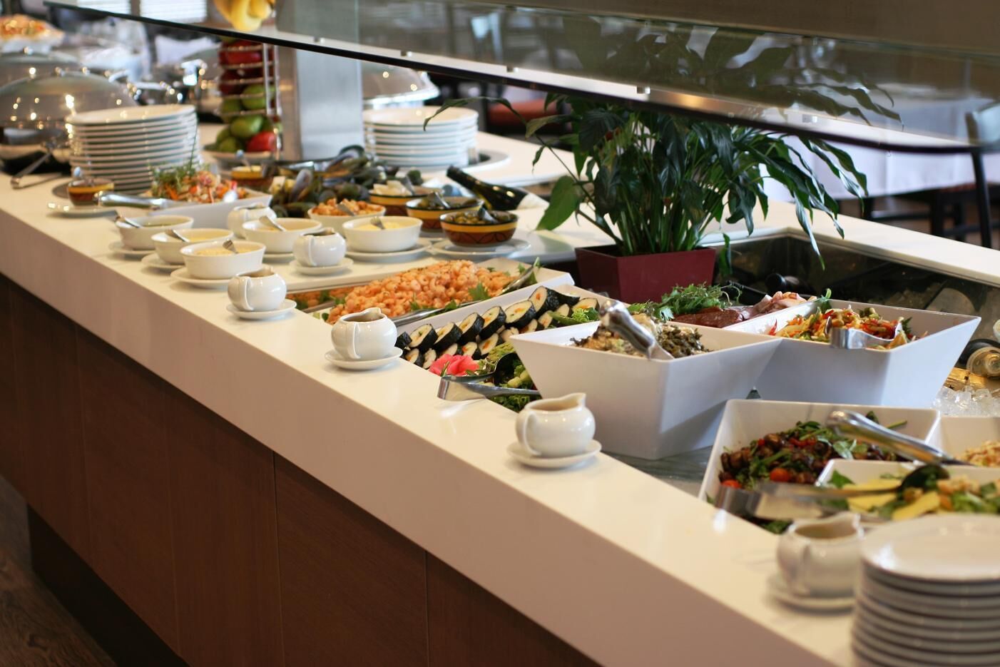 A buffet with various food items and dishes.