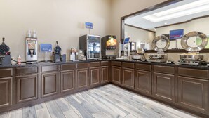 A hotel breakfast area with a marble floor, a refrigerator, a coffee machine, and a microwave. - Best Western near Lackland AFB/SeaWorld (San Antonio)