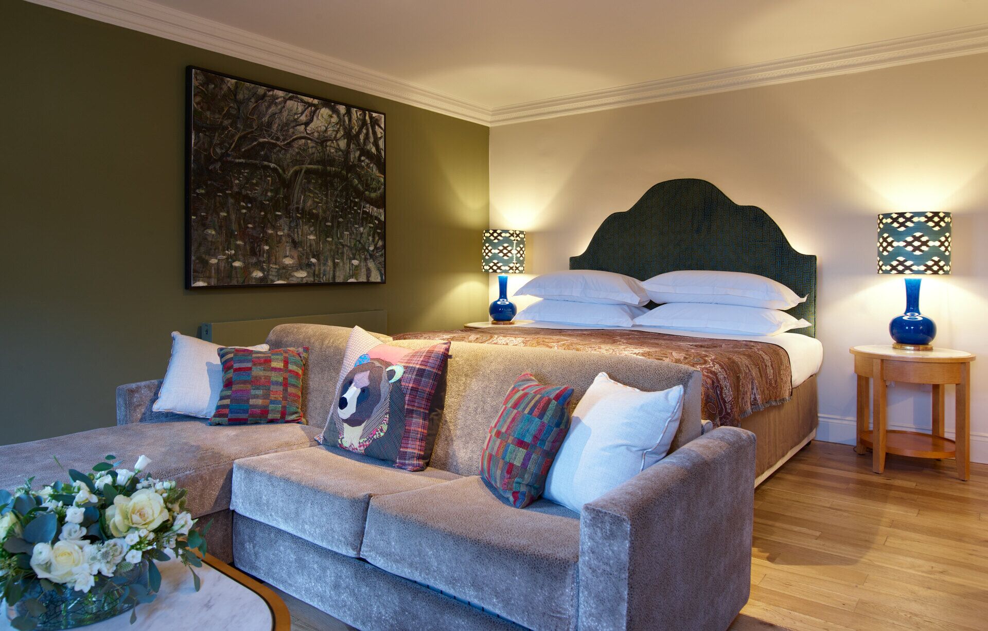 A bedroom with a bed, a sofa, and a nightstand.