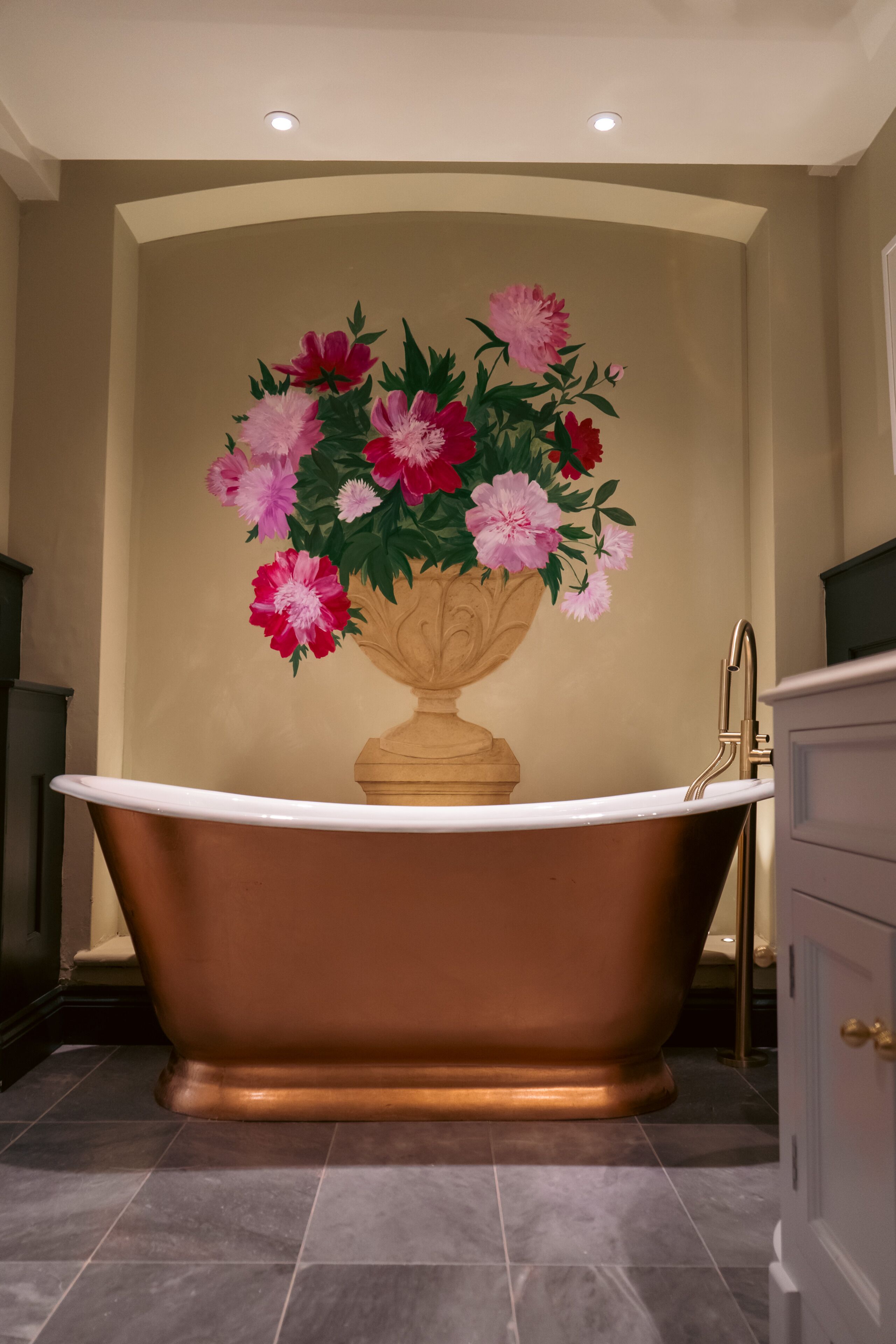 A bathroom with a freestanding bathtub, a wall-mounted sink, and a cabinet.