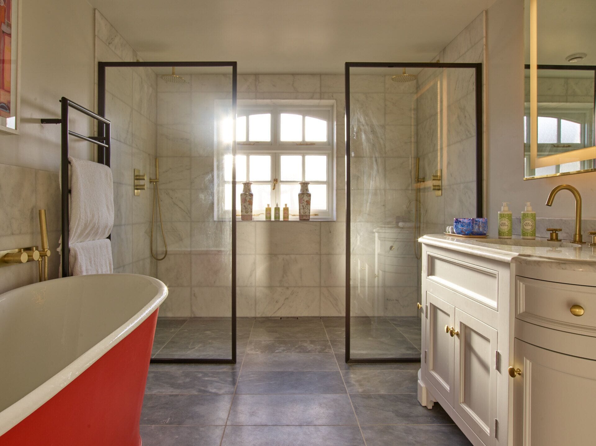 Ein modernes Badezimmer mit freistehender Badewanne, einer begehbaren Dusche und einem Waschtisch mit Spiegel.