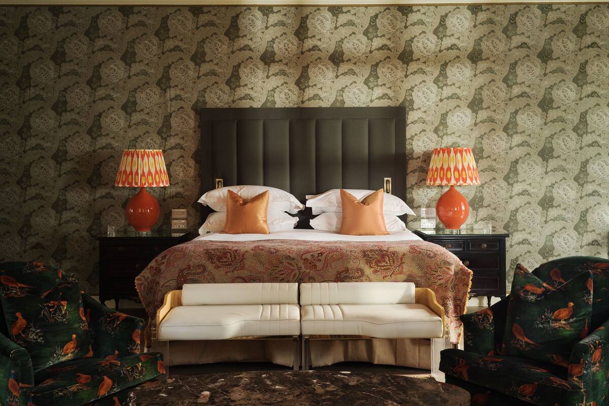 A bedroom with a large bed, two nightstands, and two lamps.