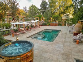 A pool area with lounge chairs and a hot tub.