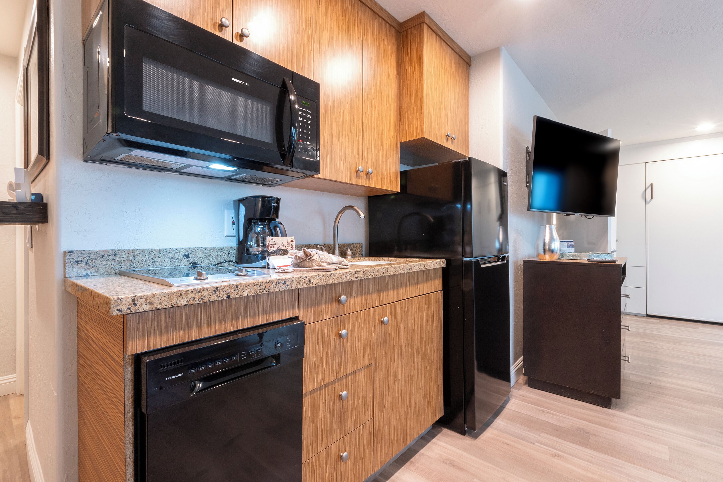 A modern kitchen with a built-in microwave, refrigerator, and dishwasher.