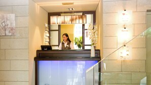 A reception desk with a sign reading "RECEPTION" and a woman standing behind it.