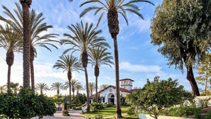 A well-maintained garden with palm trees and a building with a red-tiled roof. - Omni La Costa Resort & Spa Carlsbad (Carlsbad)