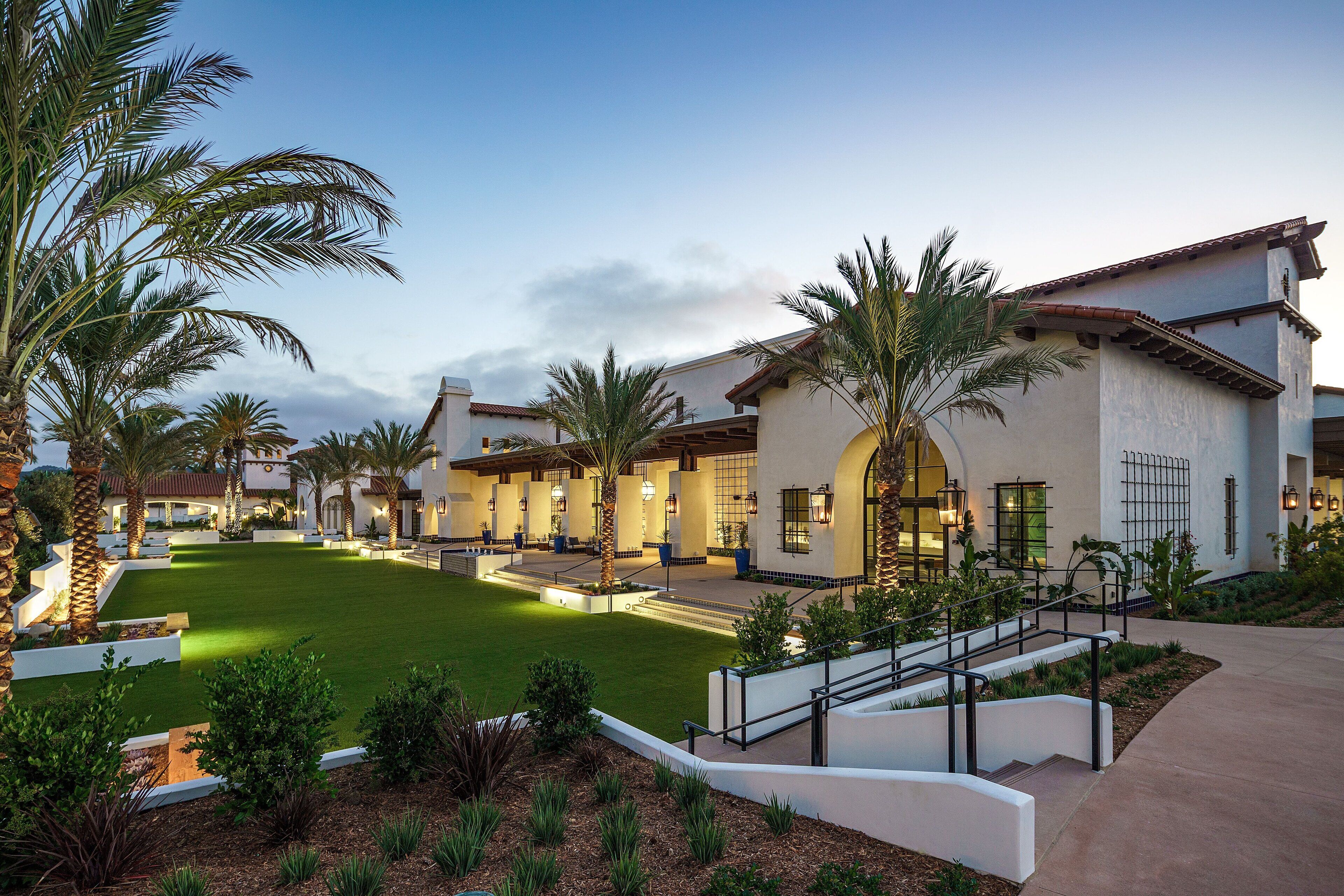 A resort with multiple villas, a central courtyard, and palm trees.
