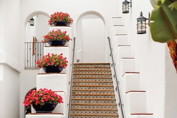 A hotel corridor with open sliding doors leading to balconies with flower beds and a clear view of the outside. at Omni La Costa Resort & Spa Carlsbad