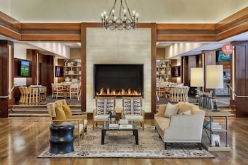 A room with a large window, a sofa, a coffee table, and patterned cushions. at Omni La Costa Resort & Spa Carlsbad