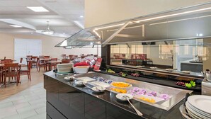 A buffet setup with various food items and dining tables. - Best Western Plus Kansas City Sports Complex Hotel (Kansas City)