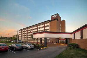 A Best Western Plus hotel with a parking lot, multiple floors, and a red and white color scheme.