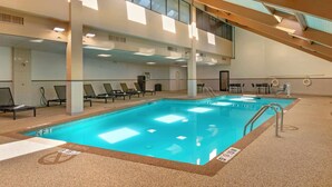 An indoor swimming pool with multiple lanes, lounge chairs, and a high ceiling with skylights. - Best Western Plus Kansas City Sports Complex Hotel (Kansas City)