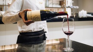 A person pouring wine into a glass.