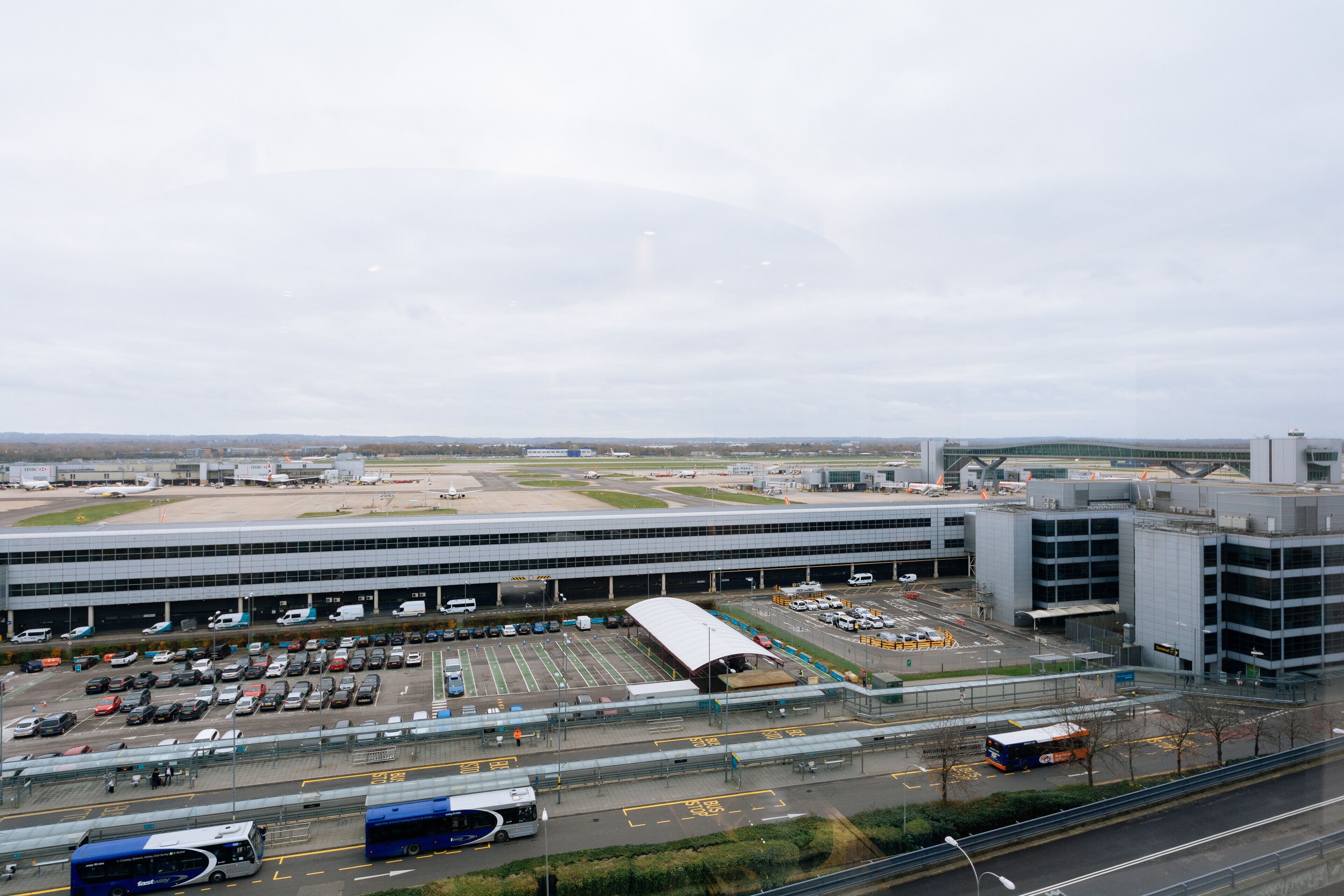 Ein Flughafen-Terminal mit mehreren Ebenen, einem Parkplatz und einem Busbahnhof.