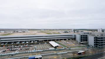 Una terminal de aeropuerto con varios niveles, un área de estacionamiento y una estación de autobuses.