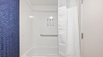Baño con ducha, toallero y dispensador de jabón para manos.