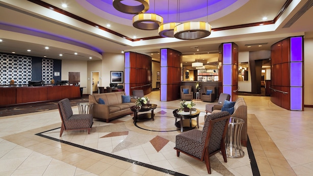 A spacious lobby with a reception desk, comfortable seating areas, and modern lighting fixtures.