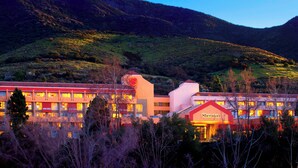 A hotel with multiple floors, a prominent Sheraton sign, and a mountainous backdrop.