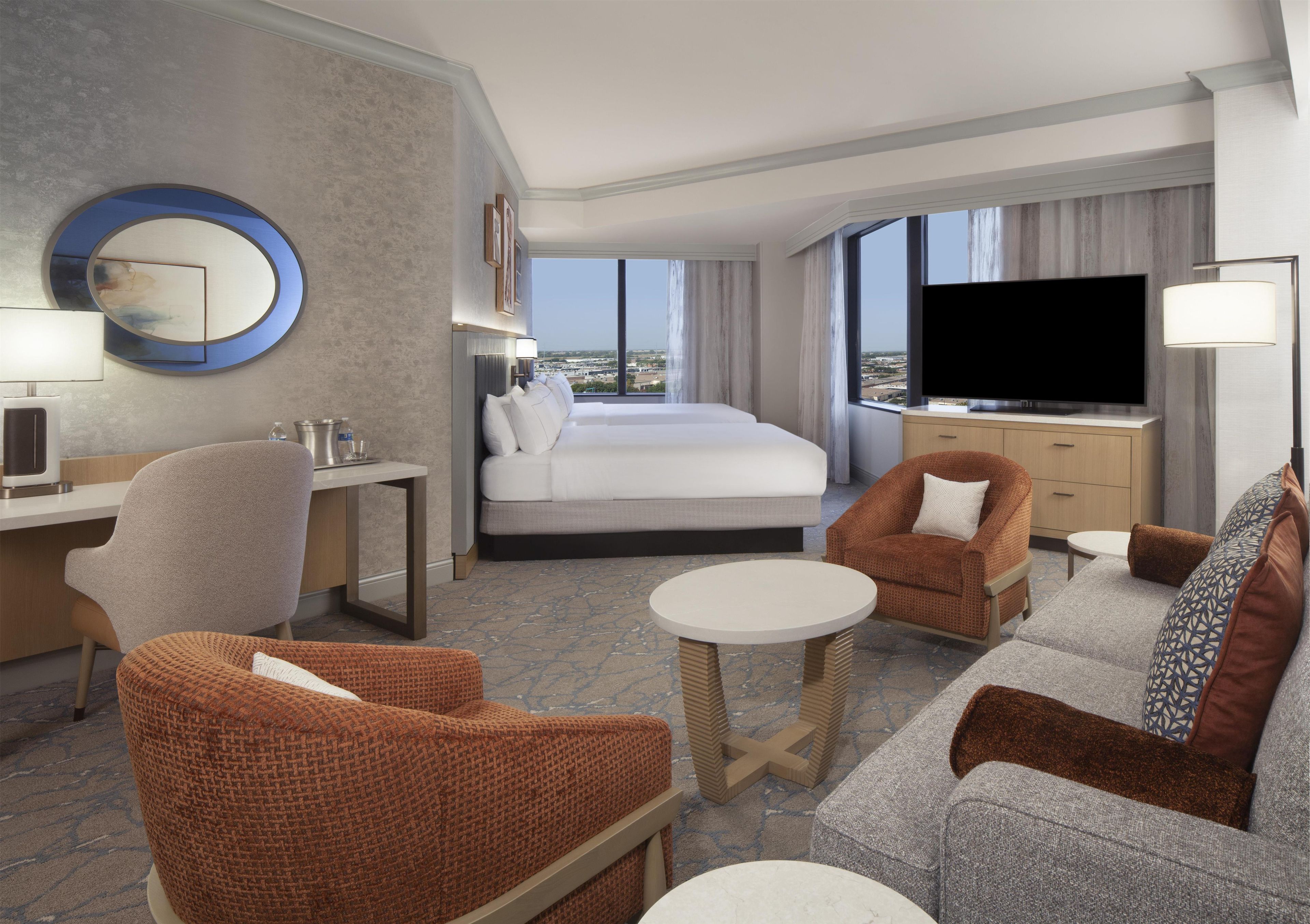 Une chambre d’hôtel équipée d’un lit, d’un bureau, d’une télévision et d’un coin salon.
