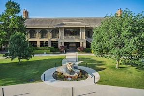 A building with a central courtyard, a large sculpture, and a well-maintained lawn.